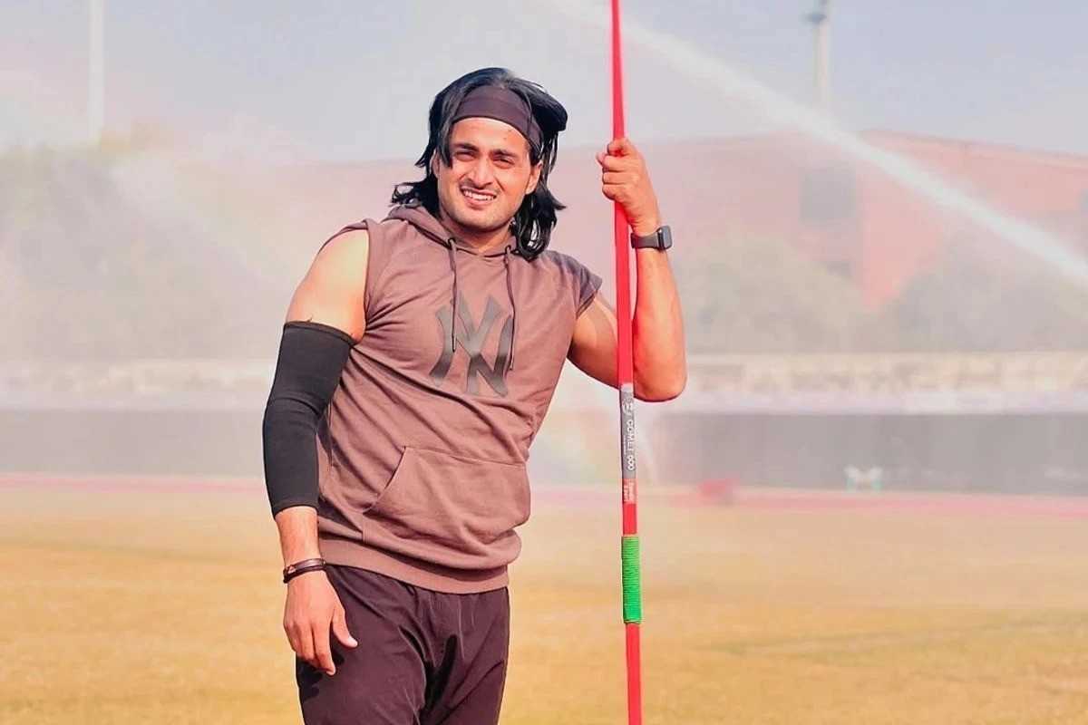 Athlete in sportswear holding a javelin on a field.