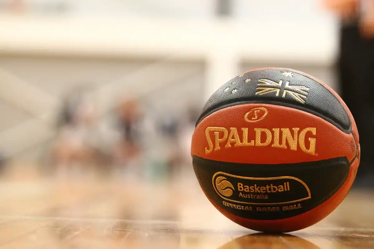 Close-up of a Spalding basketball with Australian flag on a wooden court.