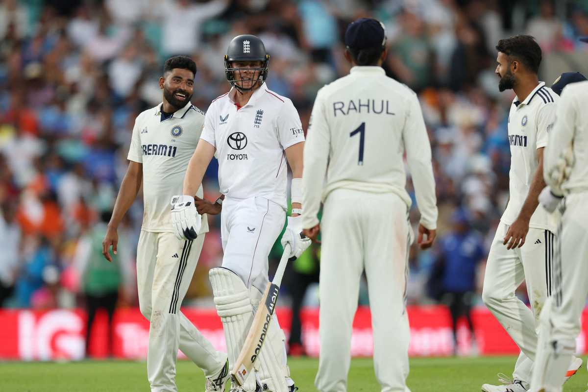 Cricket players from England and India converse on the field during a match.