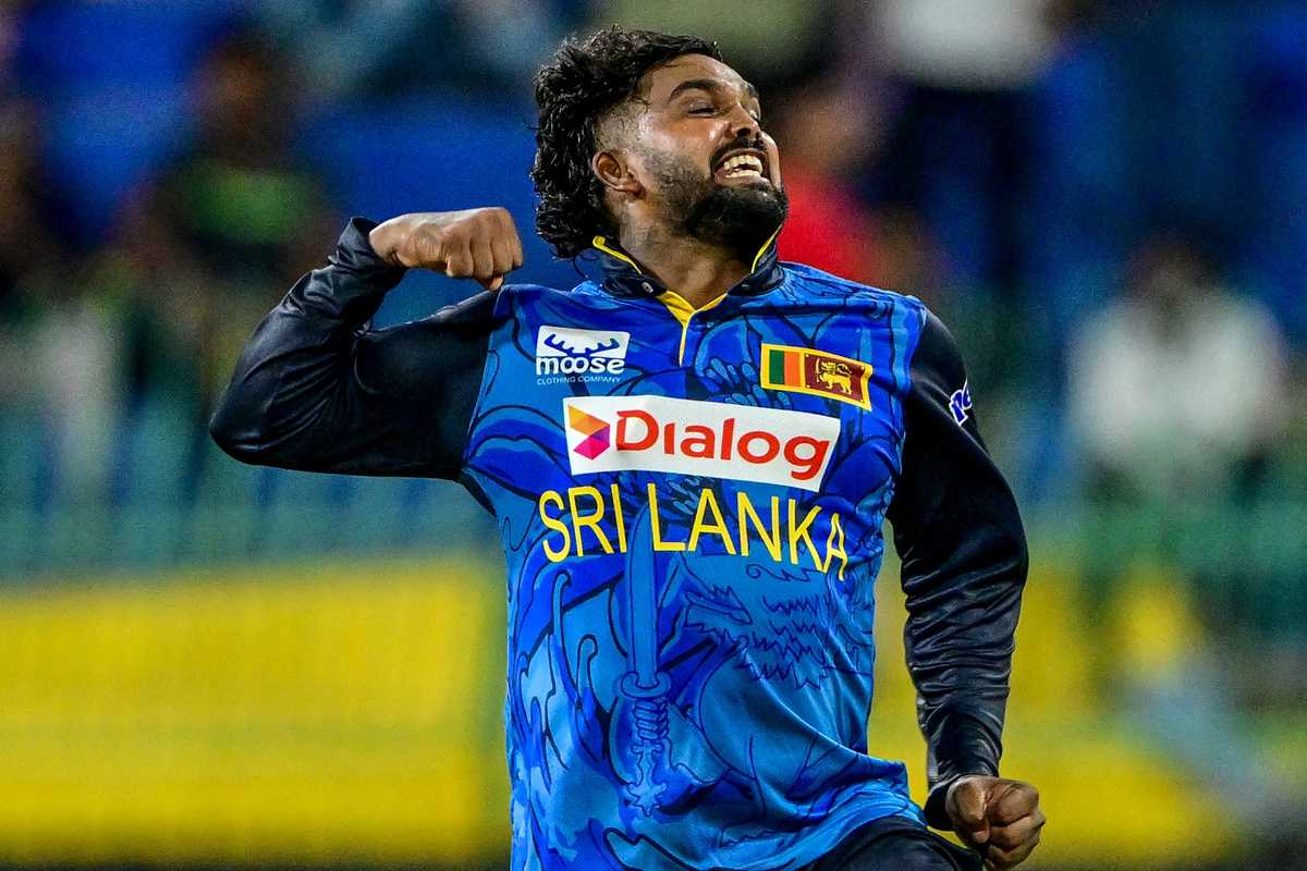 Cricketer in blue Sri Lanka jersey celebrating energetically on the field.