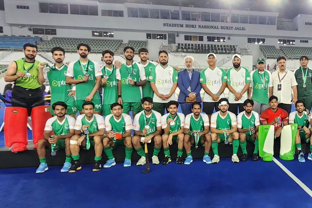 Hockey team poses with medals at Bukit Jalil stadium.