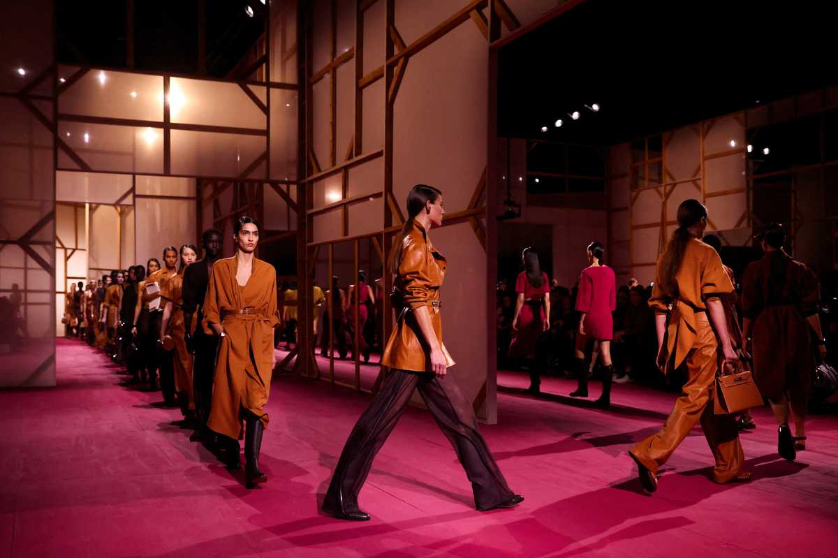 Tan leather and trio of protestors parade Hermes catwalk in Paris