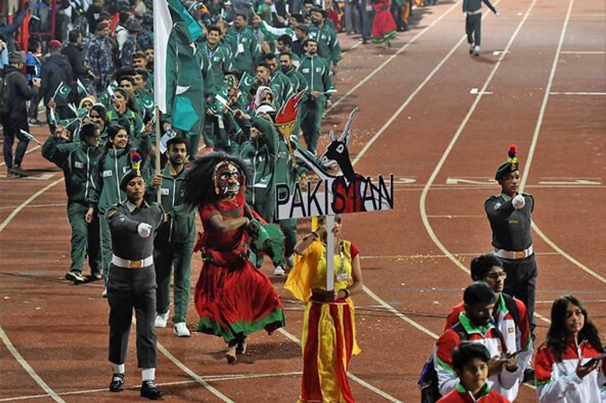 Pakistan delegation parades on track in green uniforms at an event.