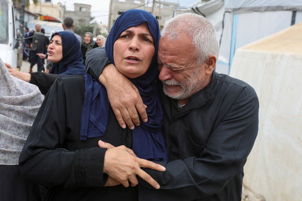 Palestinian mother Umm Ibraheem Abu Mahadi is hugged by her brother as she mourns six of her children, who were killed in an Israeli strike, during their funeral at Al-Aqsa Martyrs hospital, in Deir Al-Balah in the central Gaza Strip April 13, 2025.