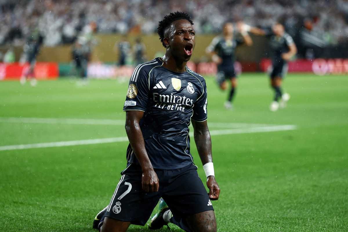 Soccer player kneels and celebrates passionately on the field.