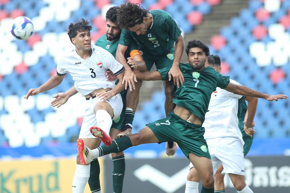 Soccer players in an intense mid-air collision during a match.