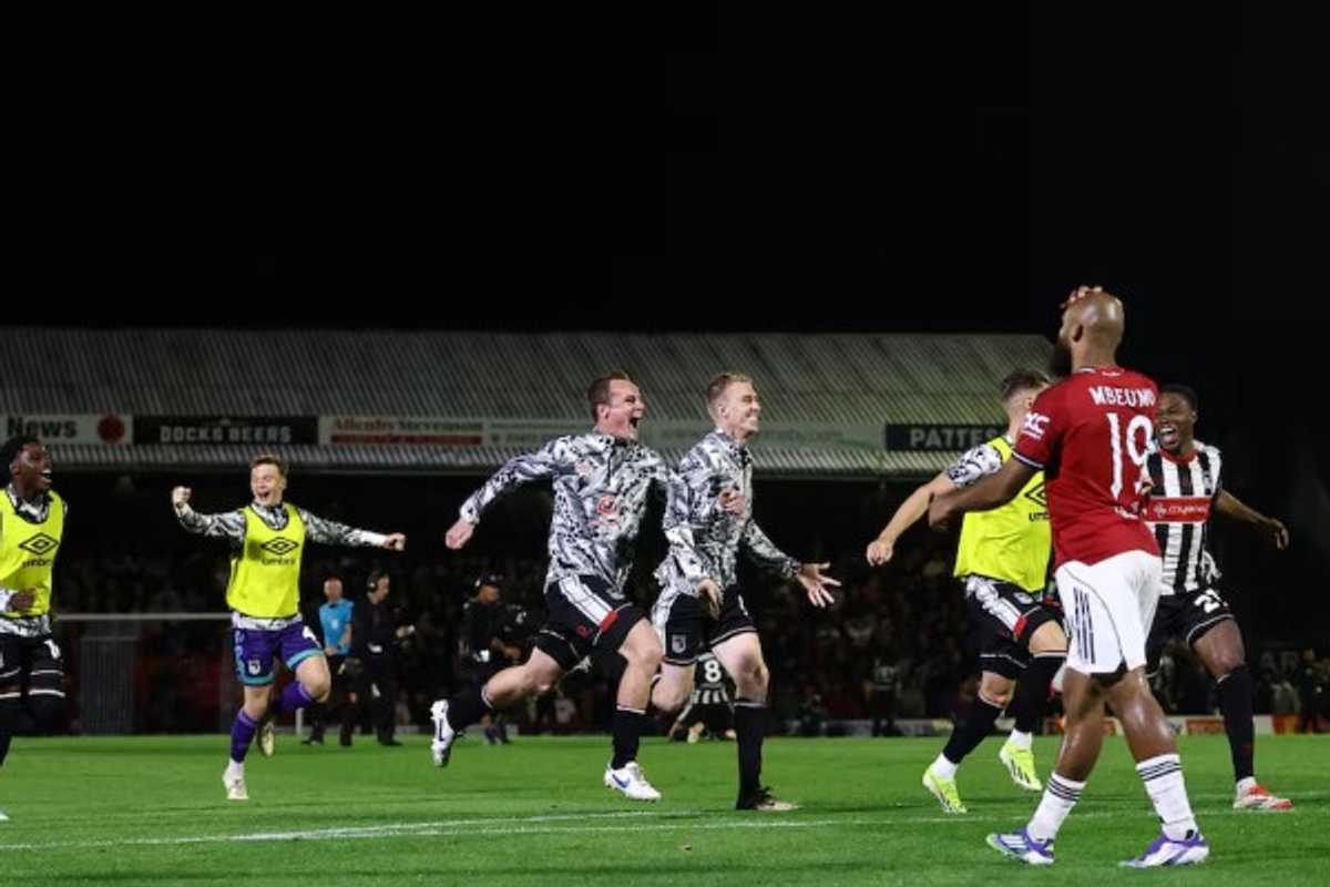 Soccer team celebrates a victory on the field during a night match.