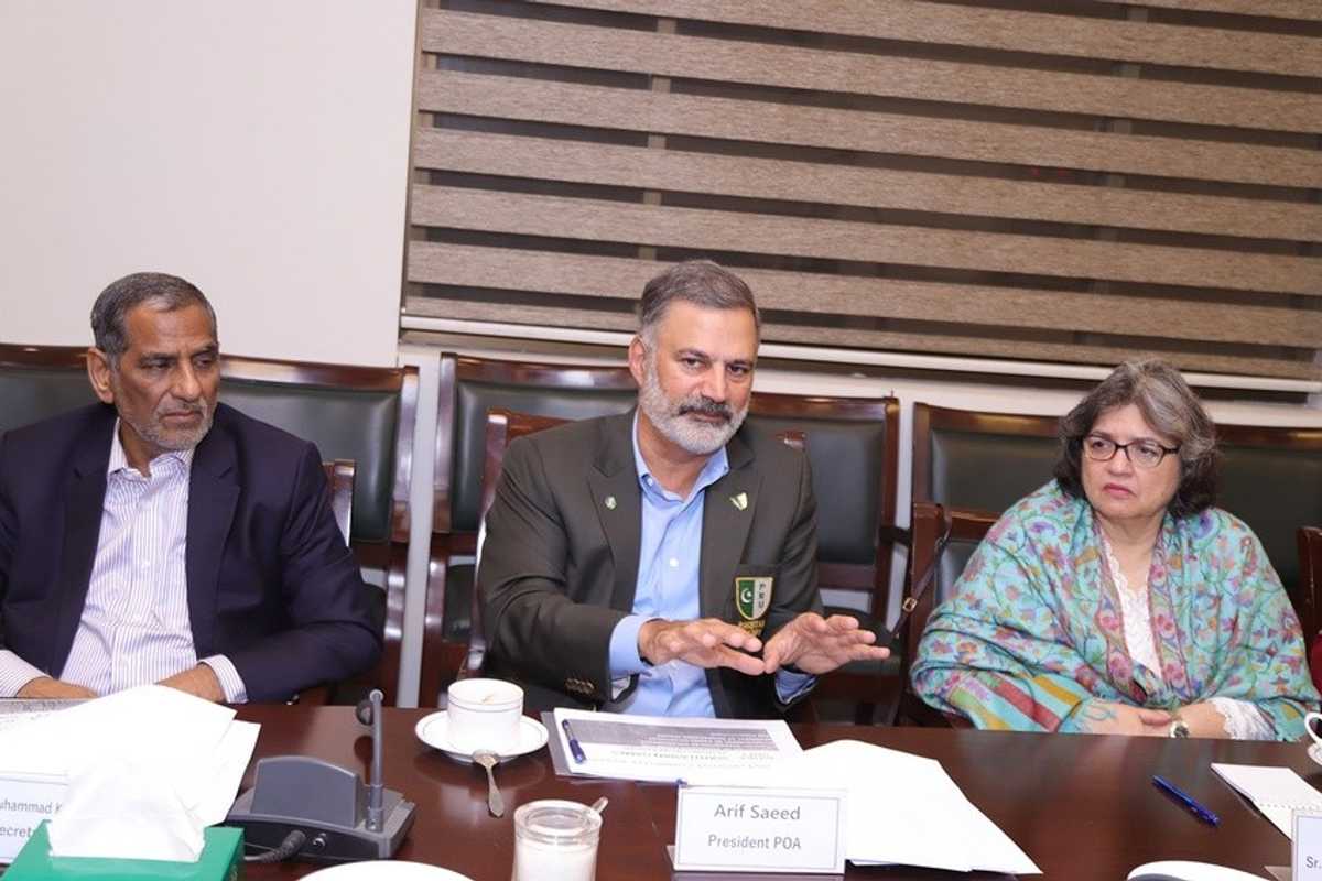 Three people at a conference table engaged in discussion.