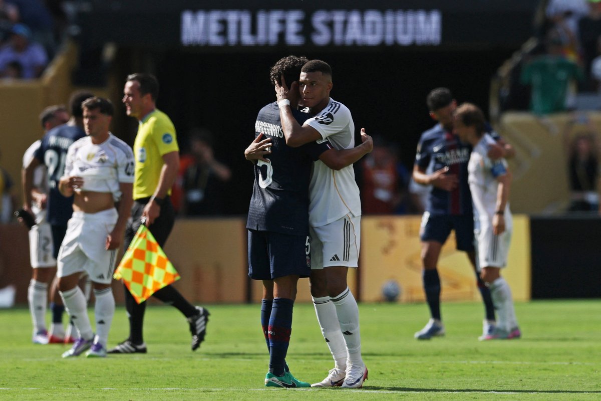 Two soccer players embrace on the field at MetLife Stadium.