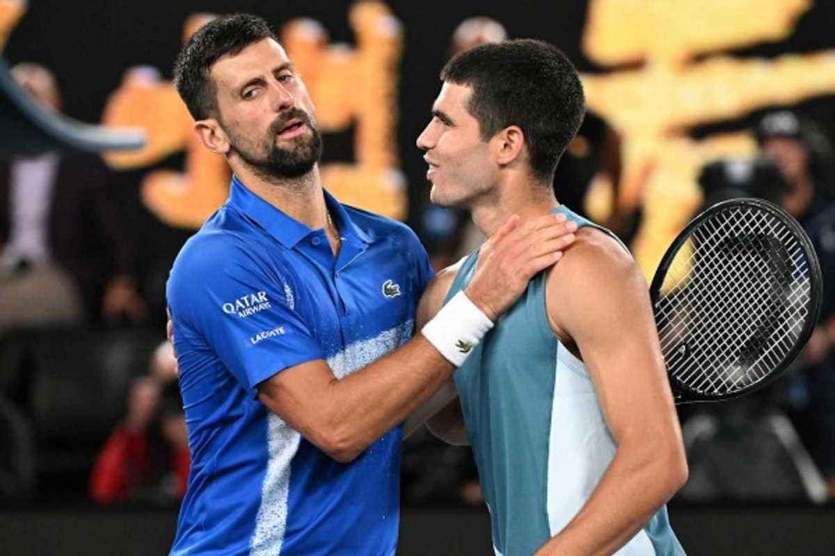 Two tennis players greet each other on the court post-match.