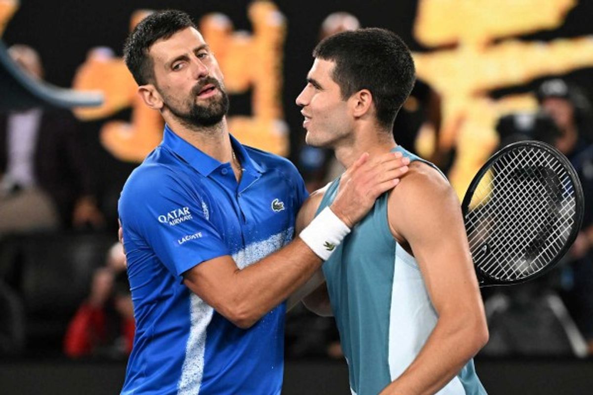 Two tennis players greet each other on the court post-match.