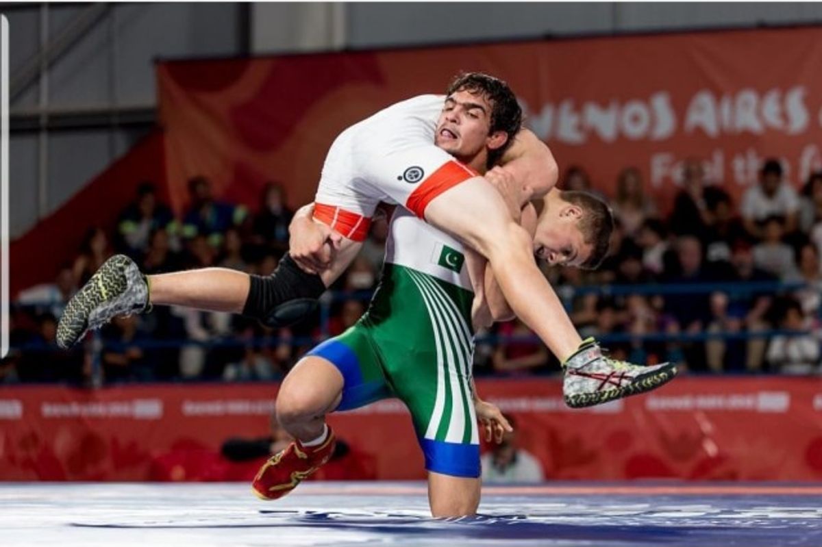 Two wrestlers in action on the mat during a match.