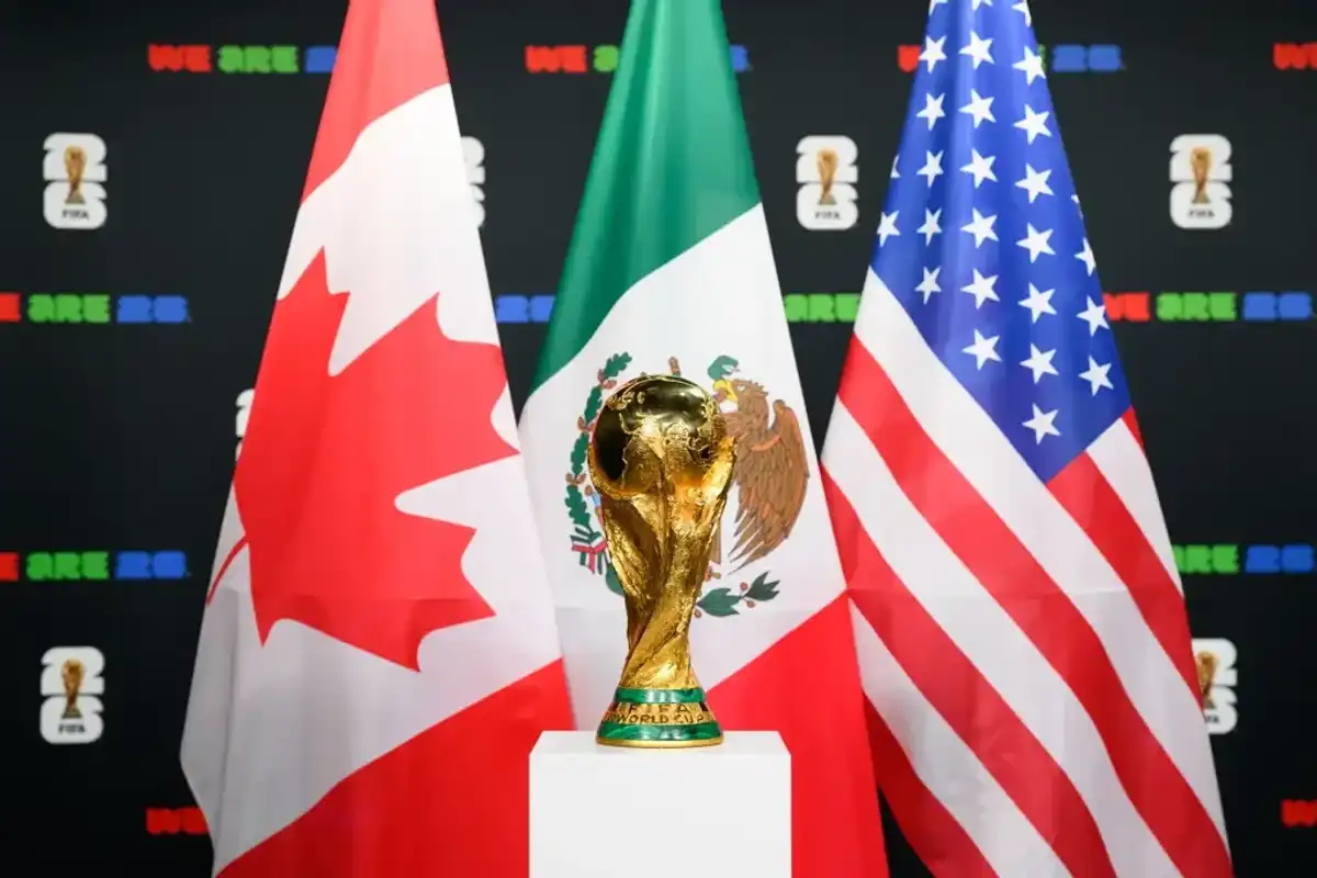 World Cup trophy with Canadian, Mexican, U.S. flags in the background.